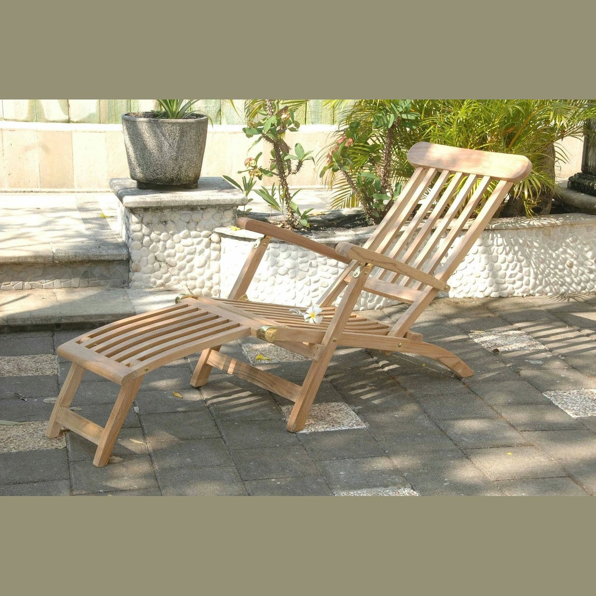 Wooden lounge chair with ottoman on a patio
