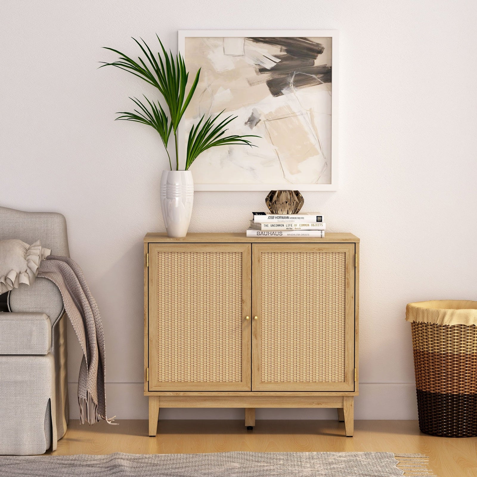 Light wooden cabinet with wicker doors in a room with a plant, books, and a painting.