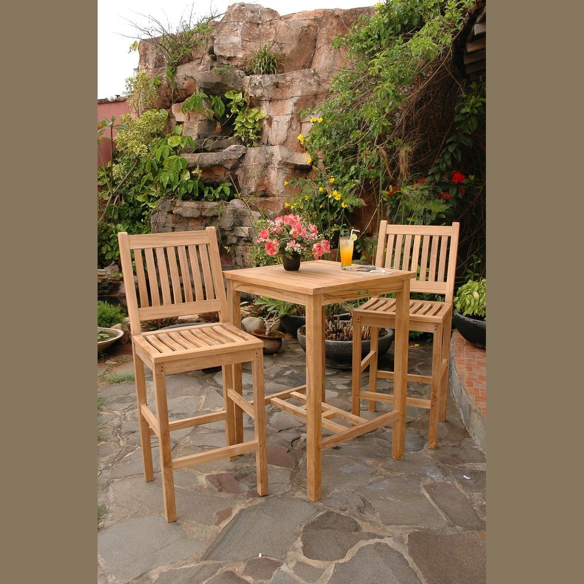 Outdoor patio set with wooden table and chairs on a stone patio.