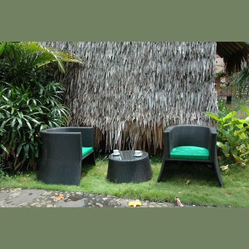 Outdoor furniture set with black chairs and table against a thatched wall.