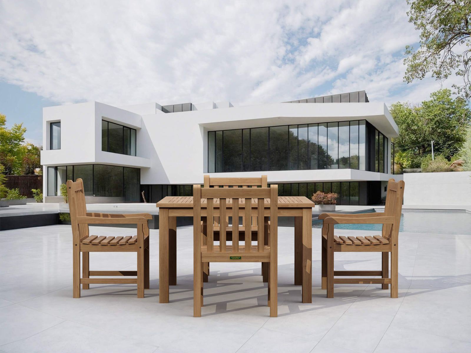 Wooden outdoor dining set with modern building and pool in the background