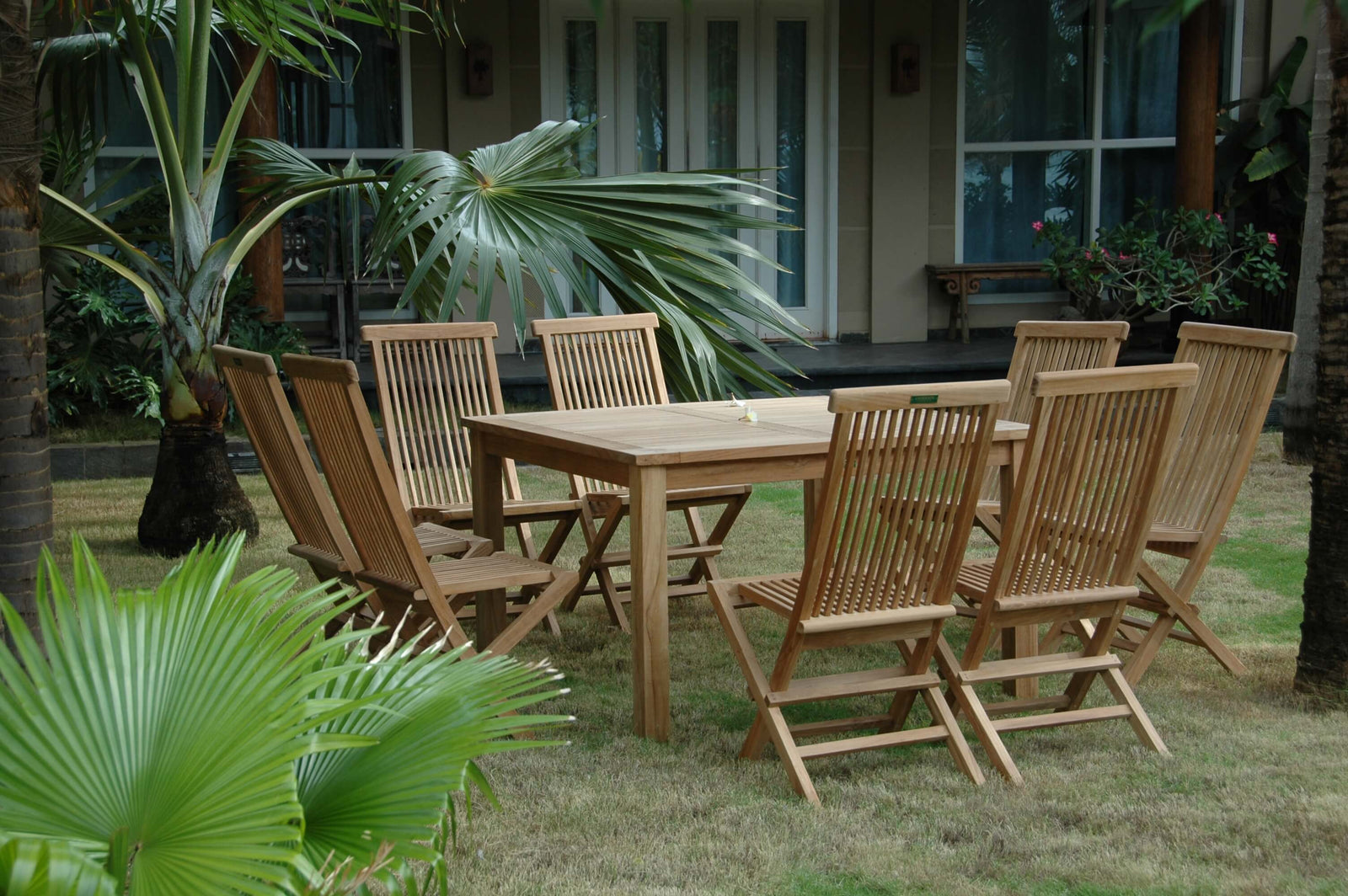 Wooden outdoor dining set with chairs and table in a garden setting