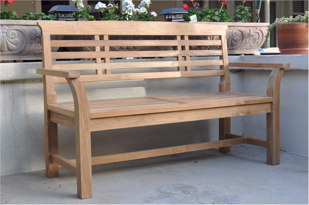 Wooden bench on a patio with decorative elements in the background