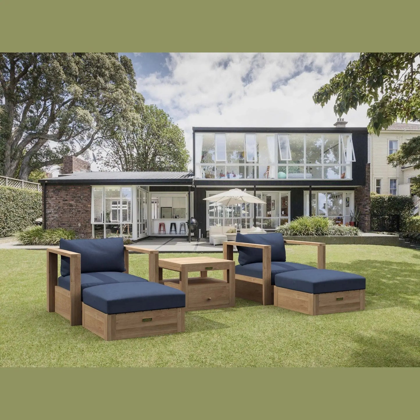 Outdoor furniture set with blue cushions on a grassy lawn in front of a modern house.