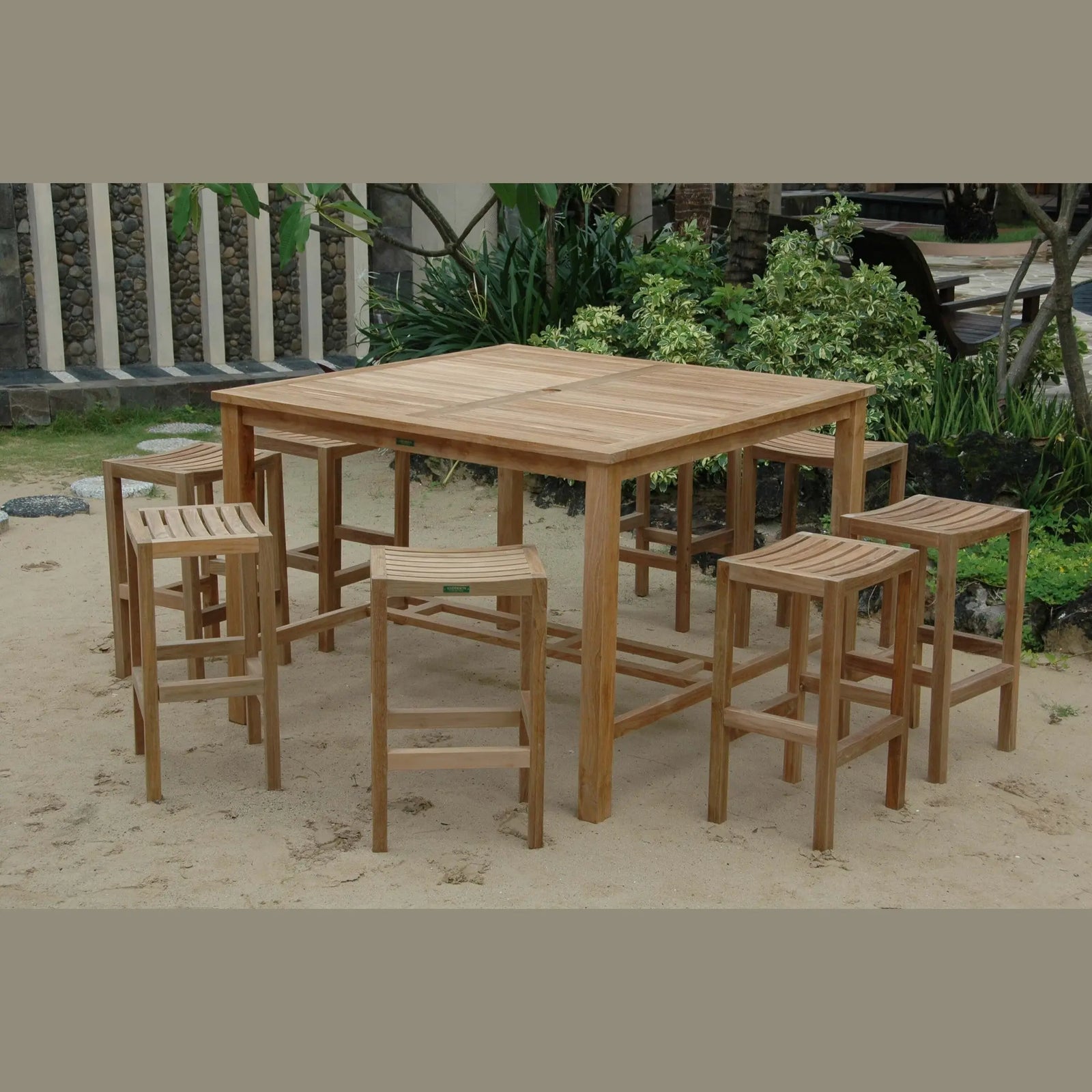Wooden outdoor dining set with table and stools on sandy ground