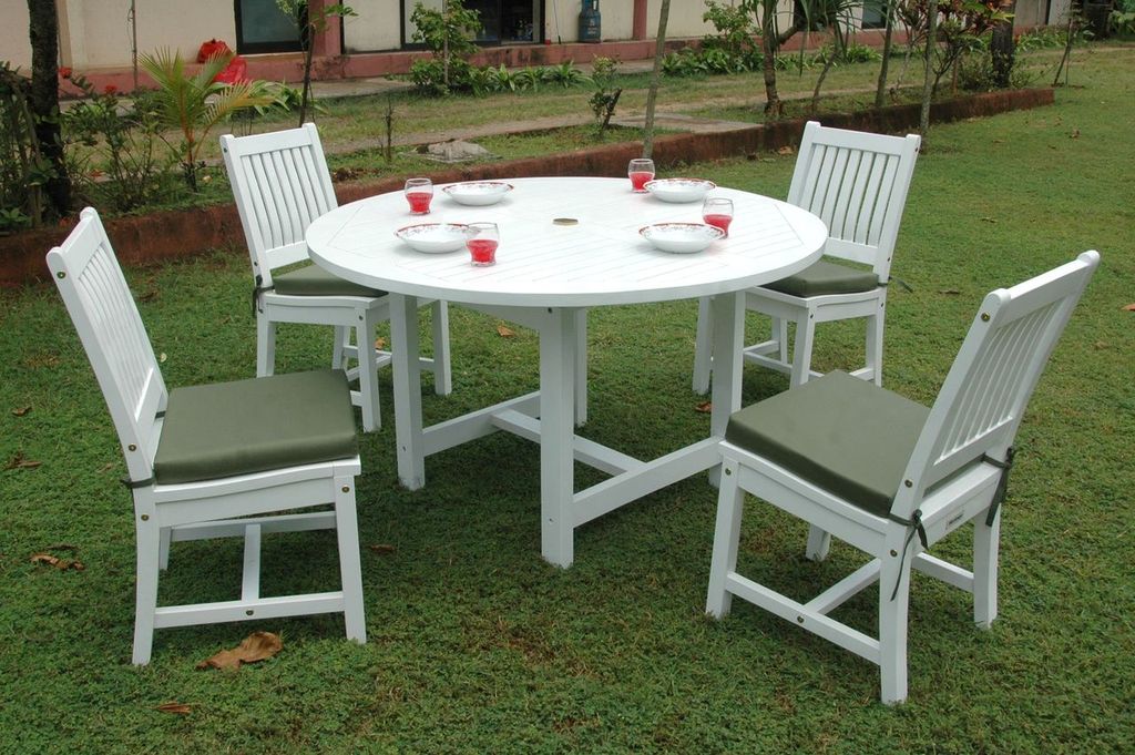 White round table with four matching chairs on a grassy area