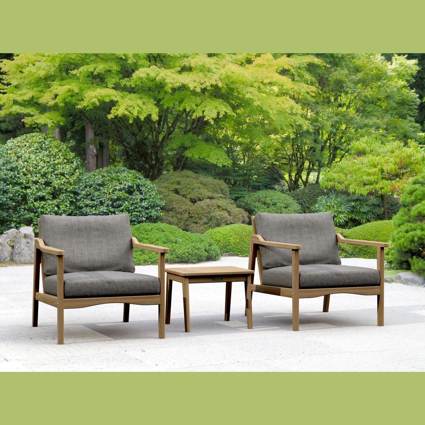 Two gray cushioned chairs with wooden frames and a matching table in a garden setting.