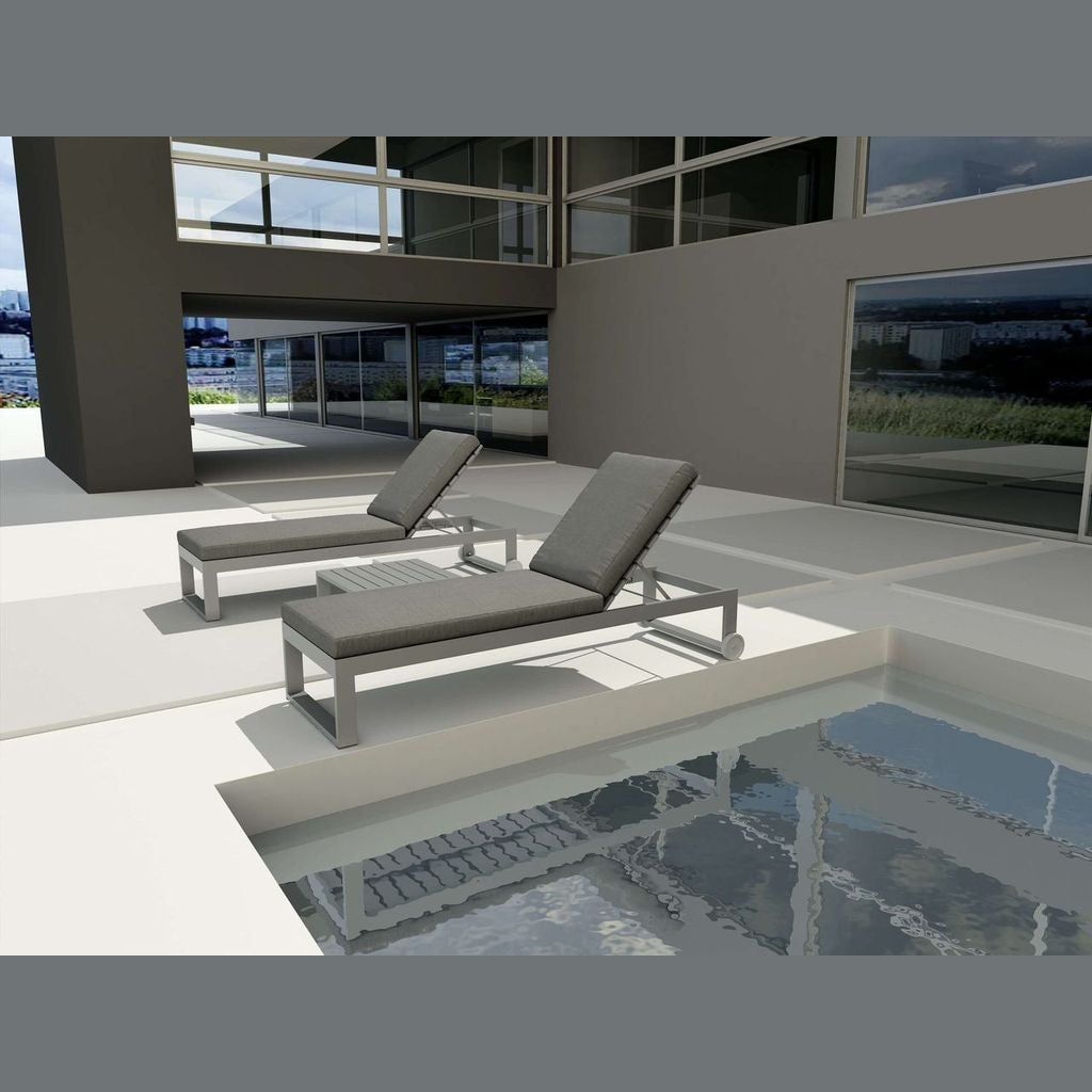 Two gray lounge chairs by a poolside in an outdoor setting.