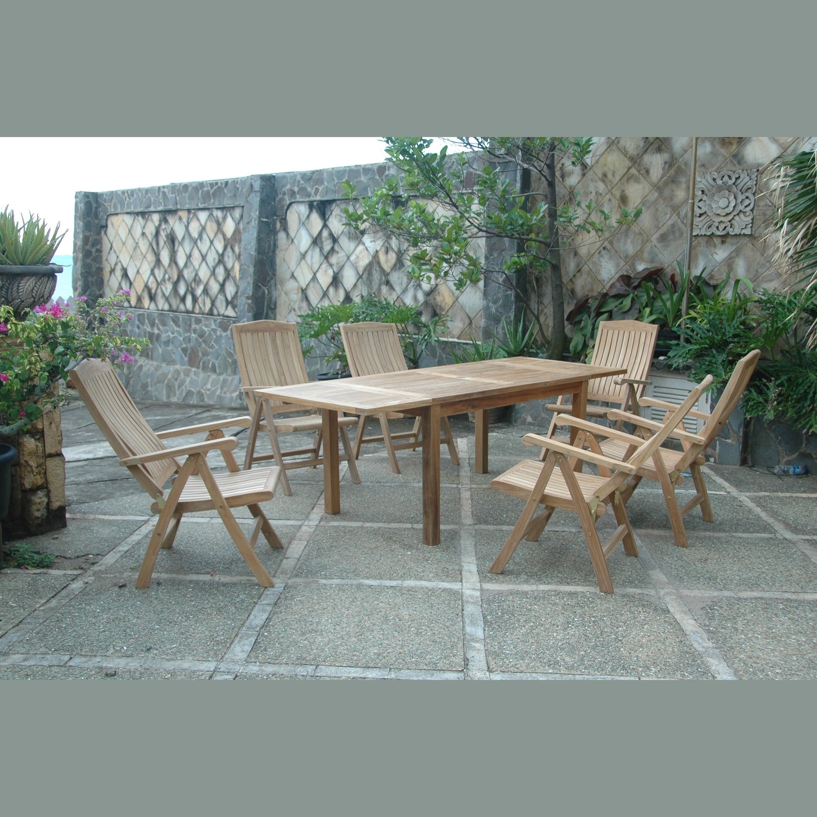 Wooden outdoor dining set with chairs on a stone patio