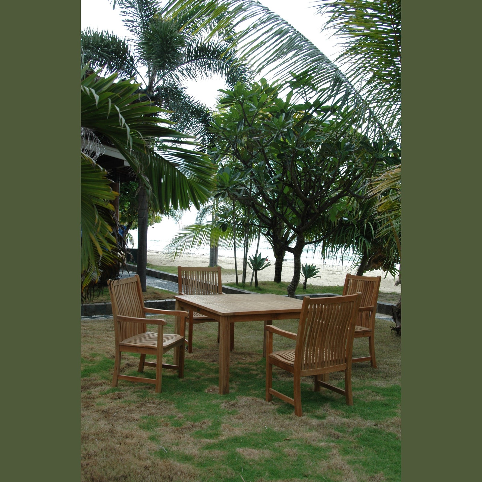 Wooden outdoor dining set with chairs on a grassy area near palm trees and a beach.