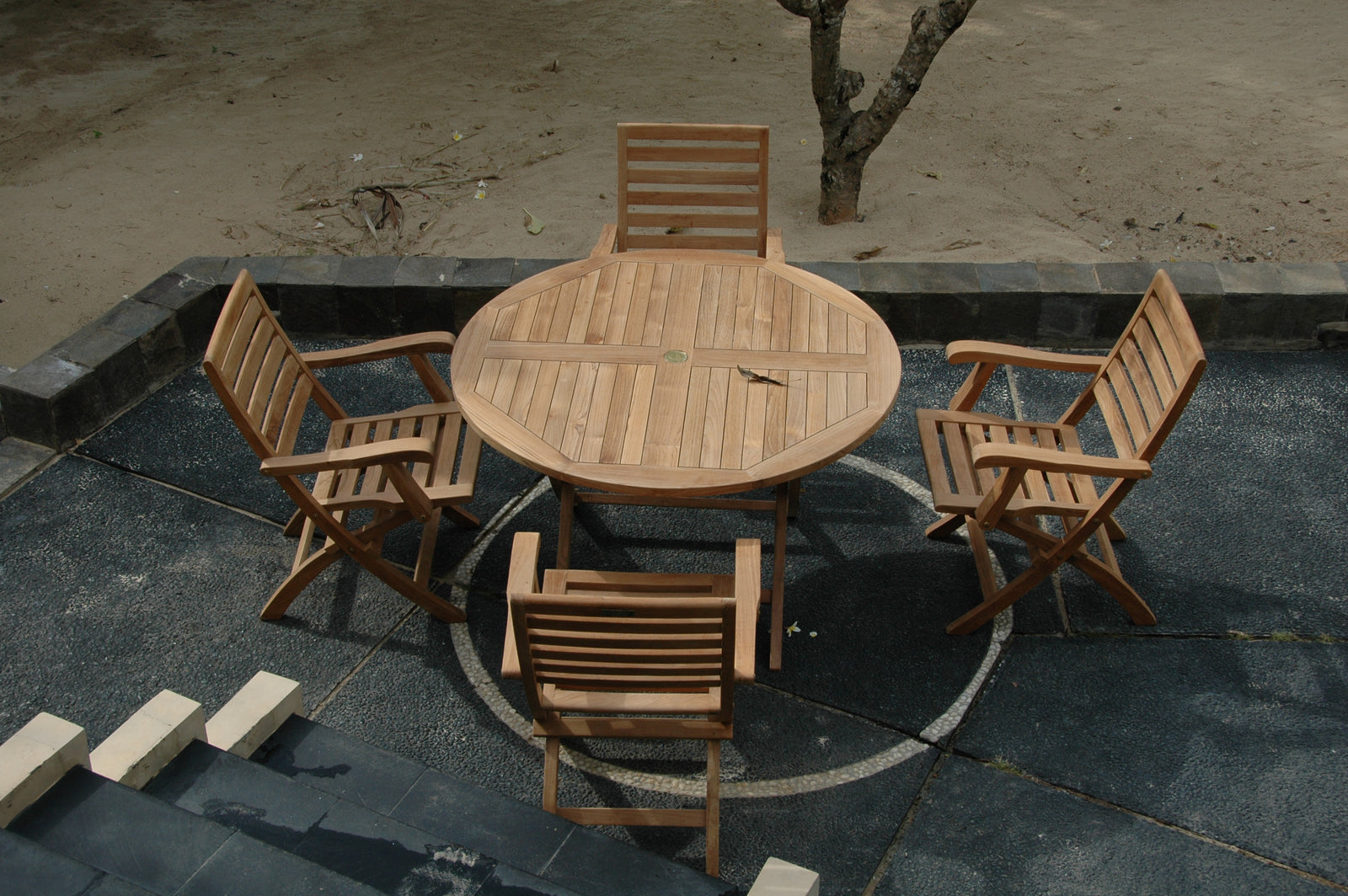 Wooden outdoor table and chairs on a stone patio