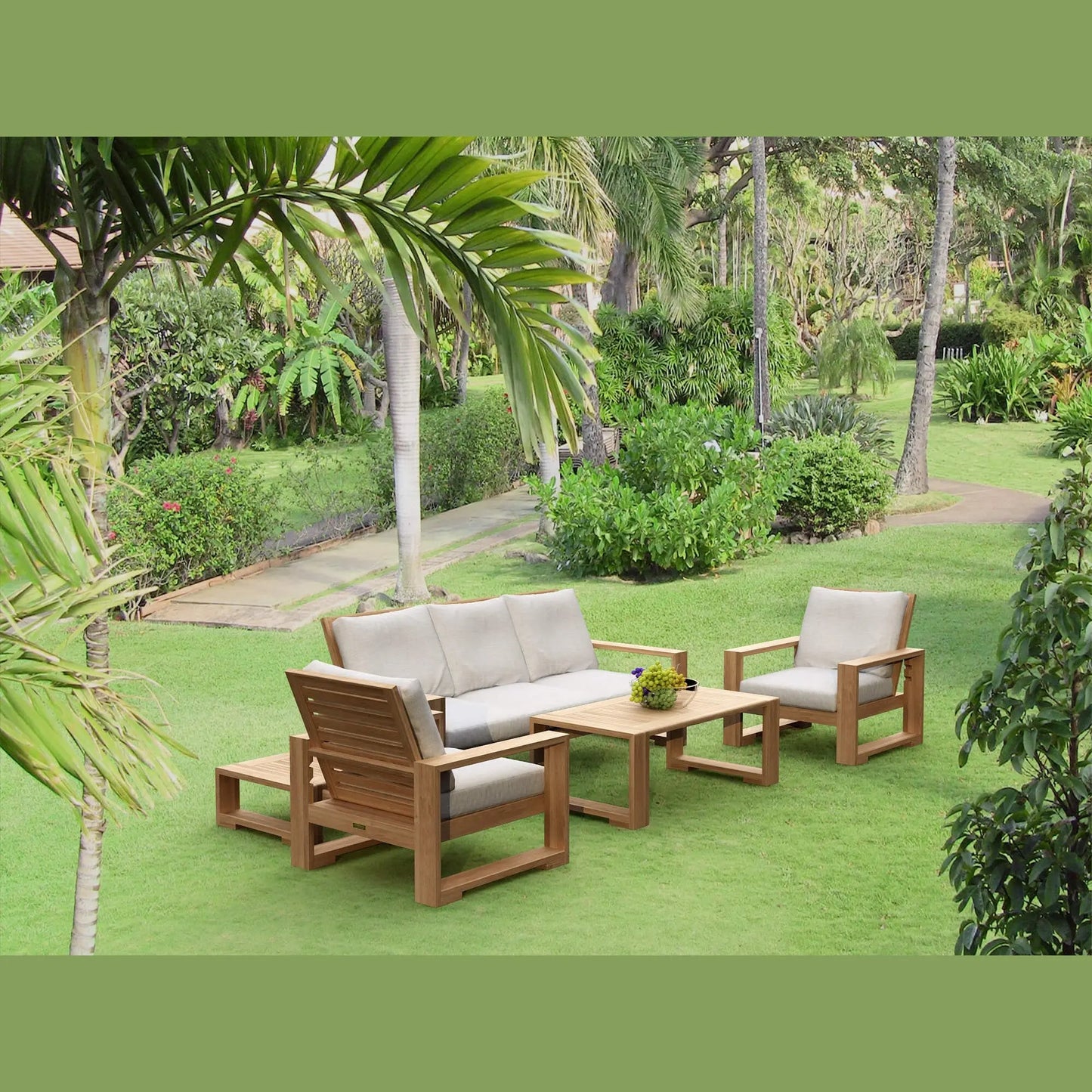 Outdoor furniture set on a grassy area with palm trees and greenery