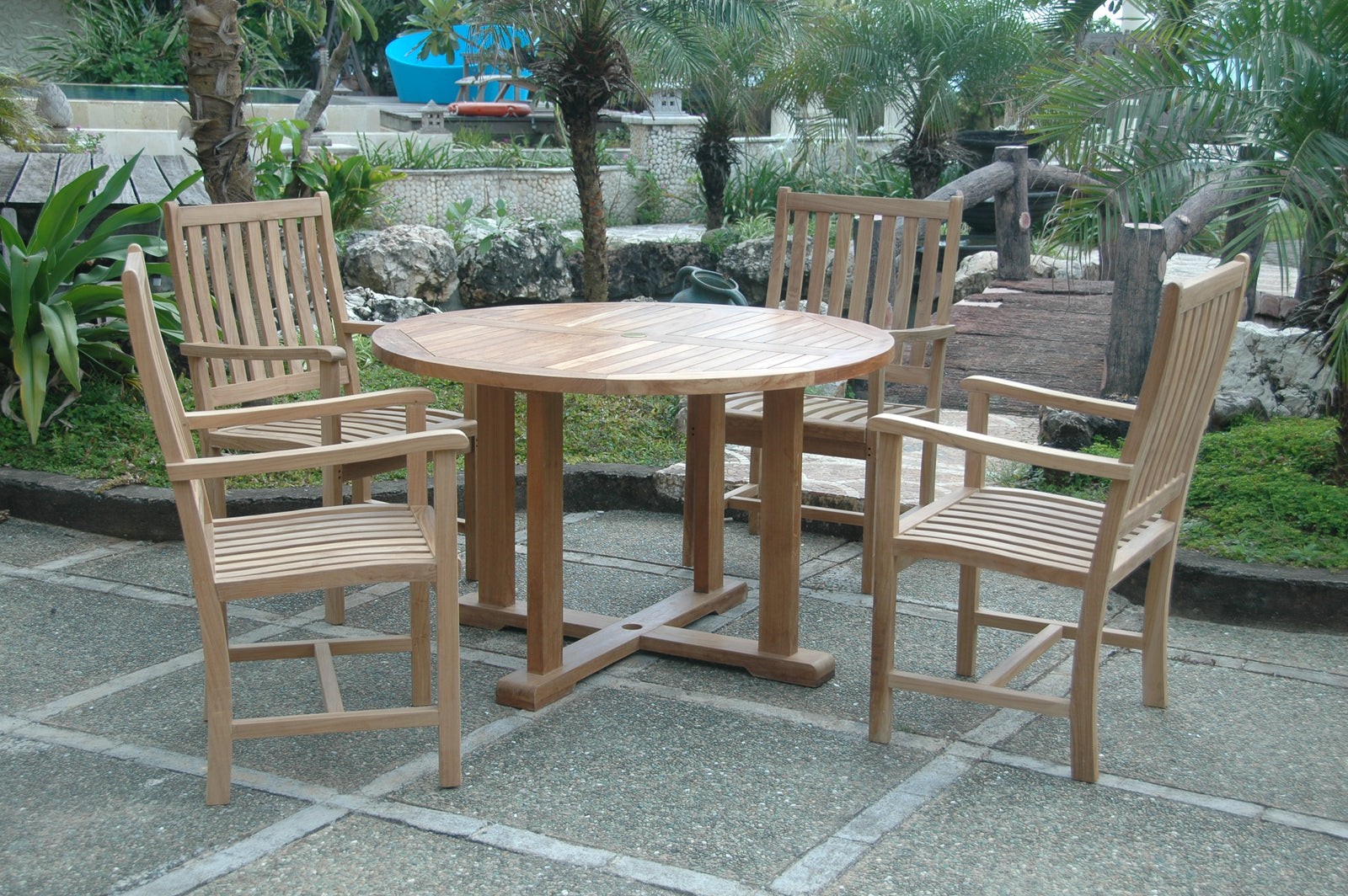 Wooden outdoor dining set with table and chairs on a stone patio