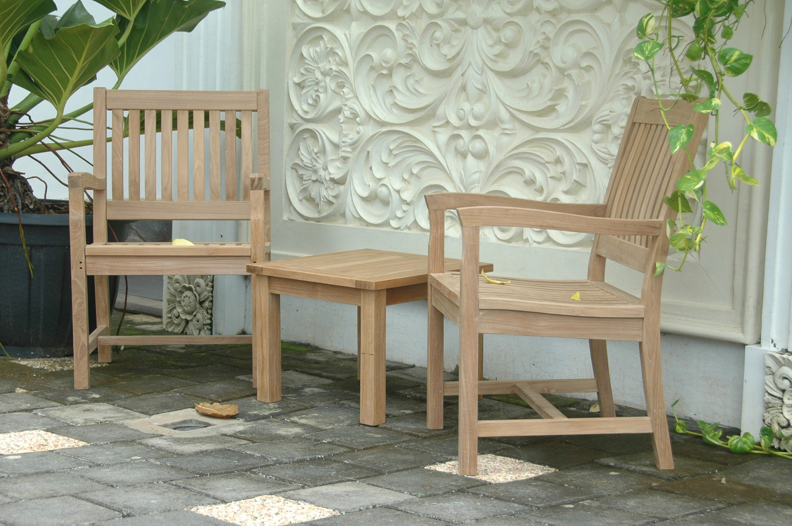 Wooden outdoor furniture set with bench and chairs on a stone patio.