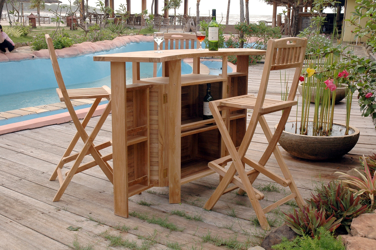 Wooden outdoor bar set with stools on a patio near a pool