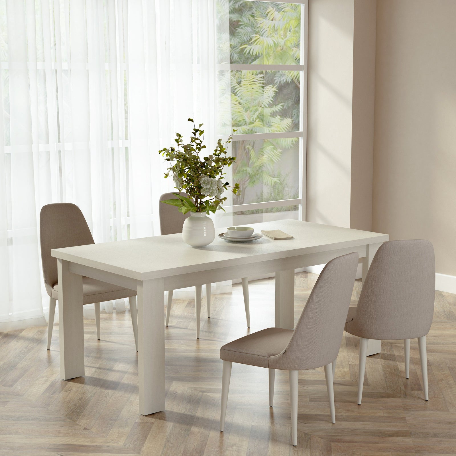 Dining room with a white table and chairs near a window with white curtains.