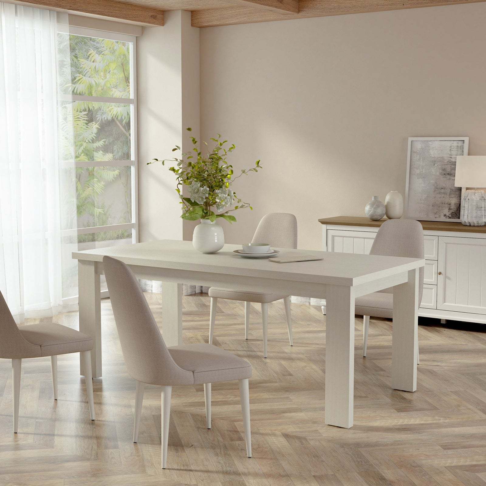 Dining room with a white table and chairs in a bright room with large windows.