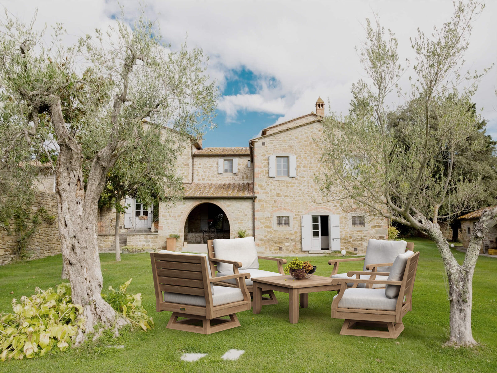 Outdoor furniture set on a grassy lawn with a stone building in the background
