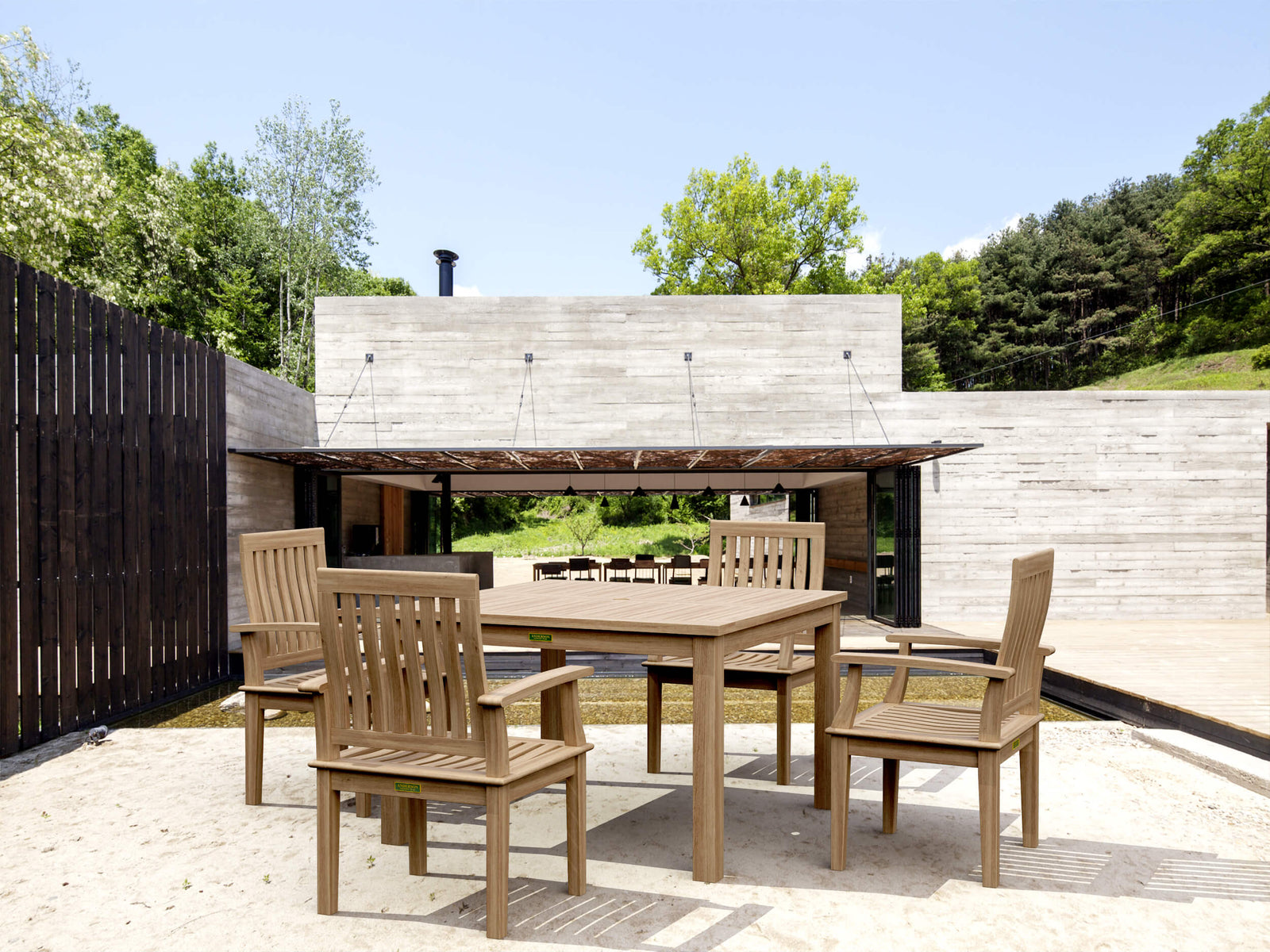 Outdoor wooden dining set with chairs on a patio area.
