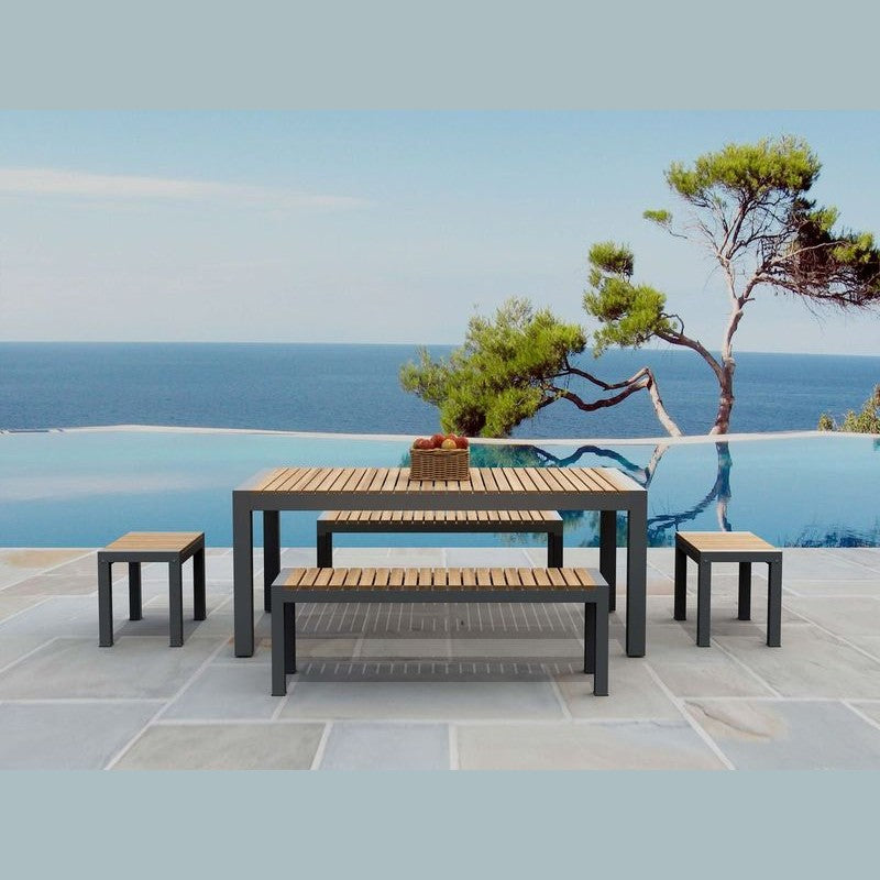Outdoor furniture set with tables and benches by a pool with ocean view