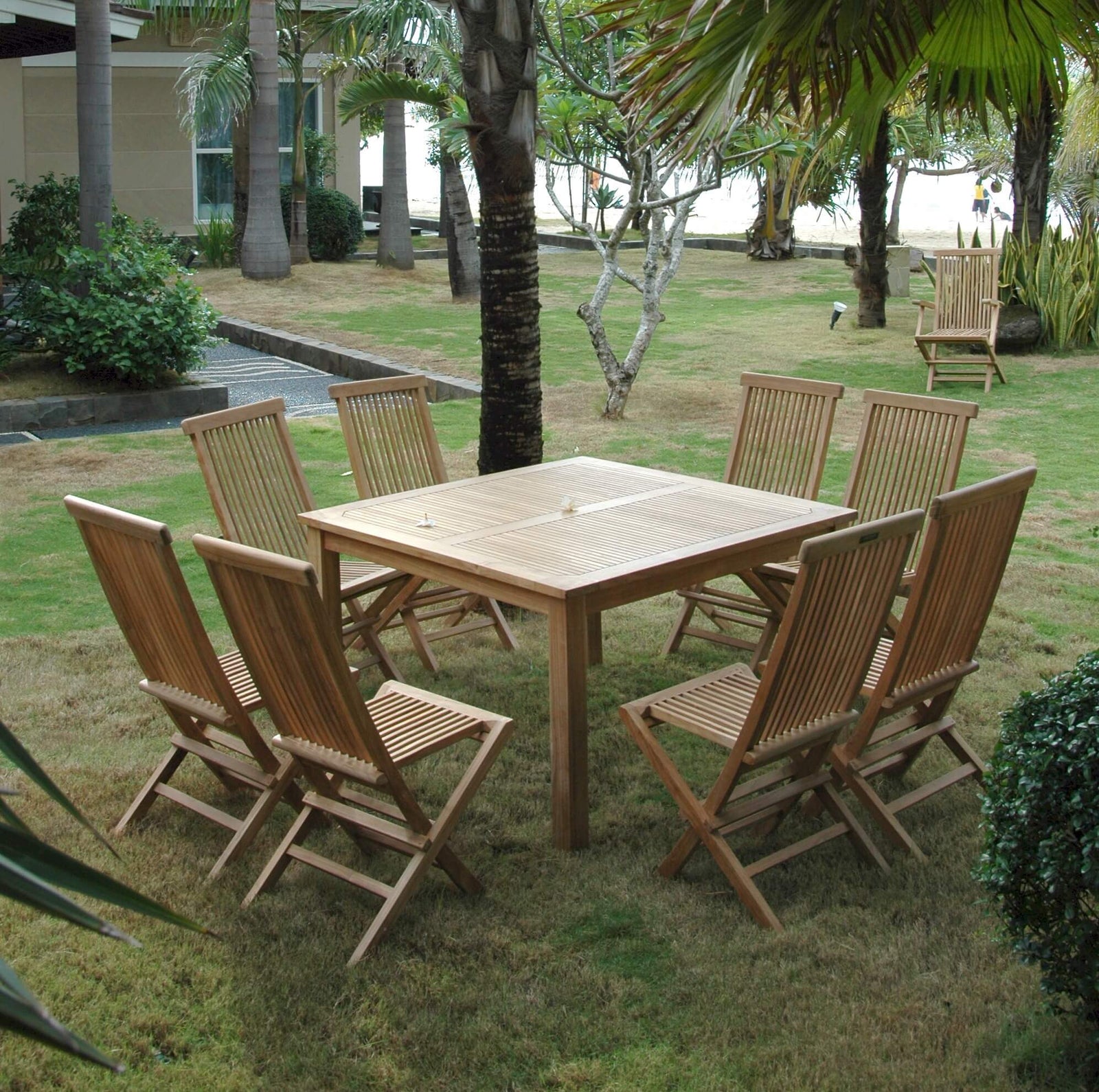Wooden outdoor dining table with chairs in a garden setting