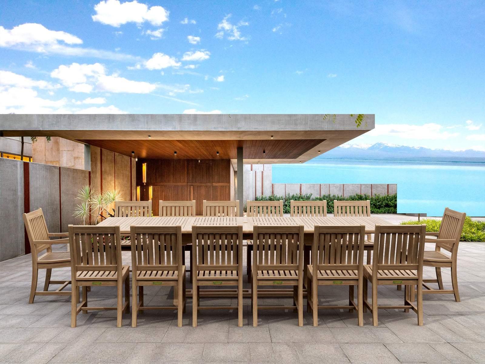 Outdoor dining set with a large table and chairs on a patio with a scenic background.