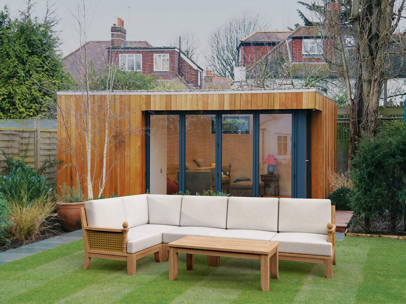 Outdoor living space with a wooden sectional sofa and coffee table in a garden setting.
