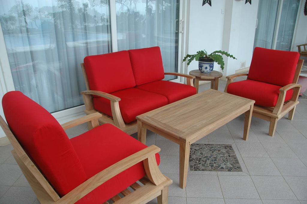 Red outdoor furniture set with wooden table on a patio