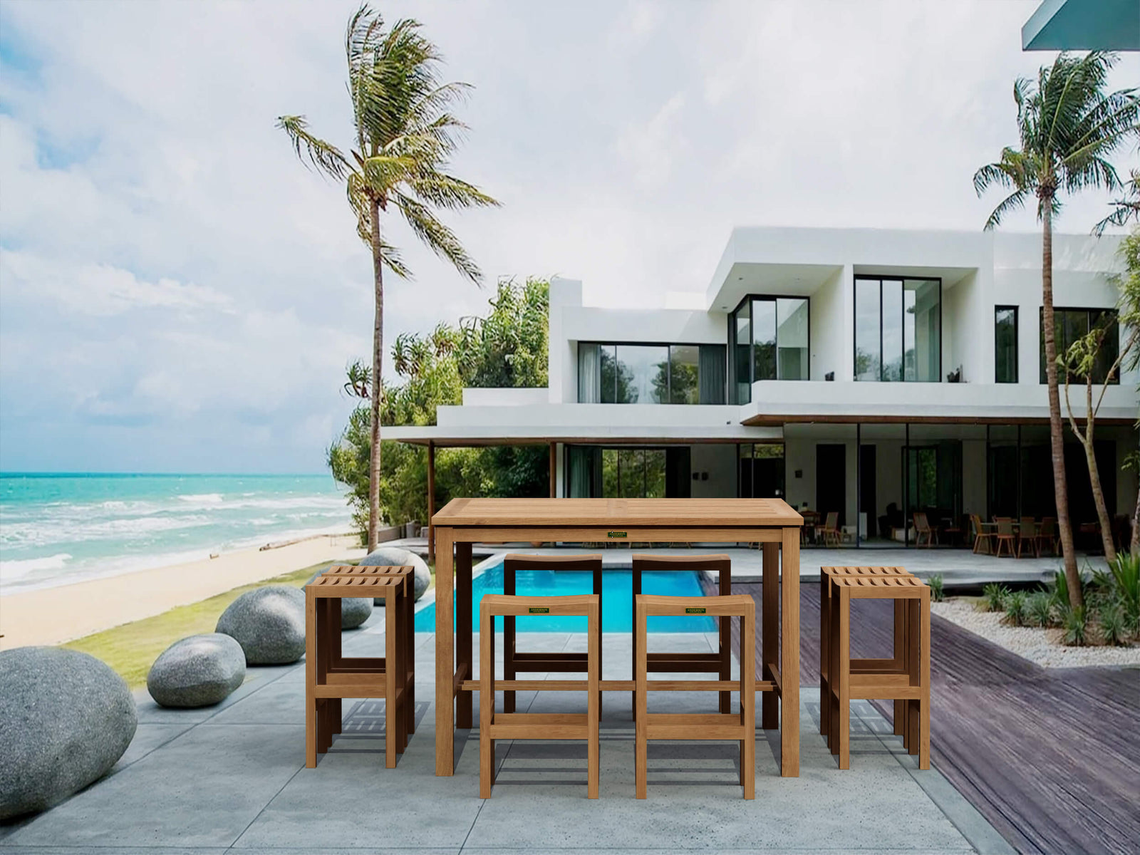 Outdoor dining set on a patio with a modern house and ocean view.