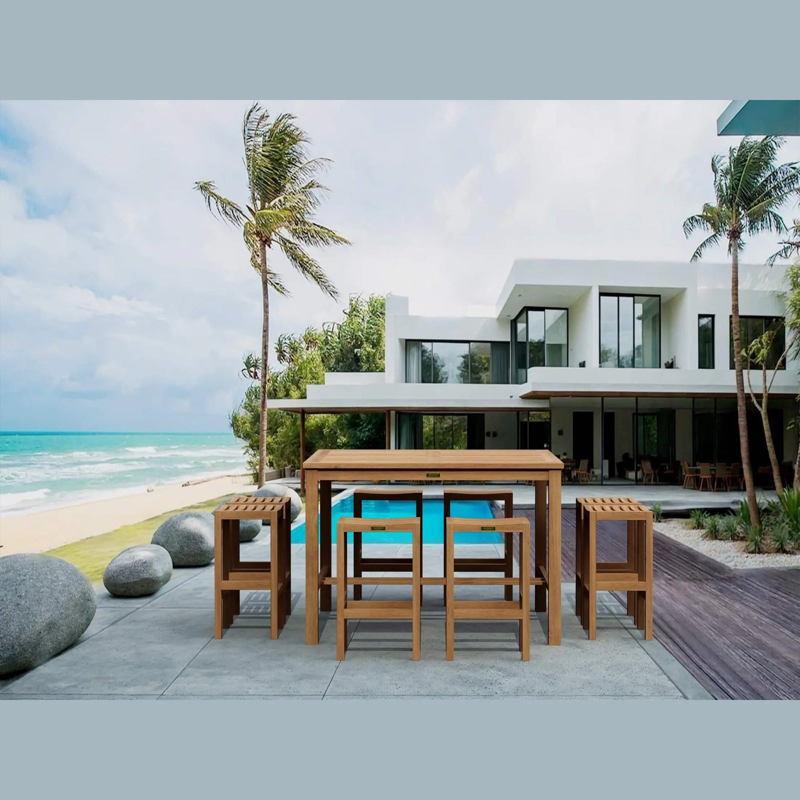 Outdoor dining set on a patio with a modern house and ocean view.