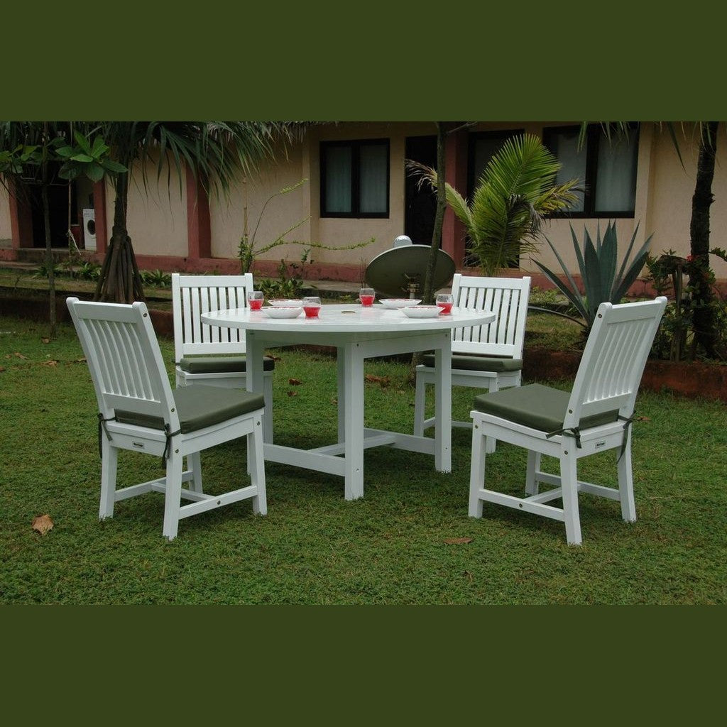 White outdoor furniture set with table and chairs on grass, house in the background