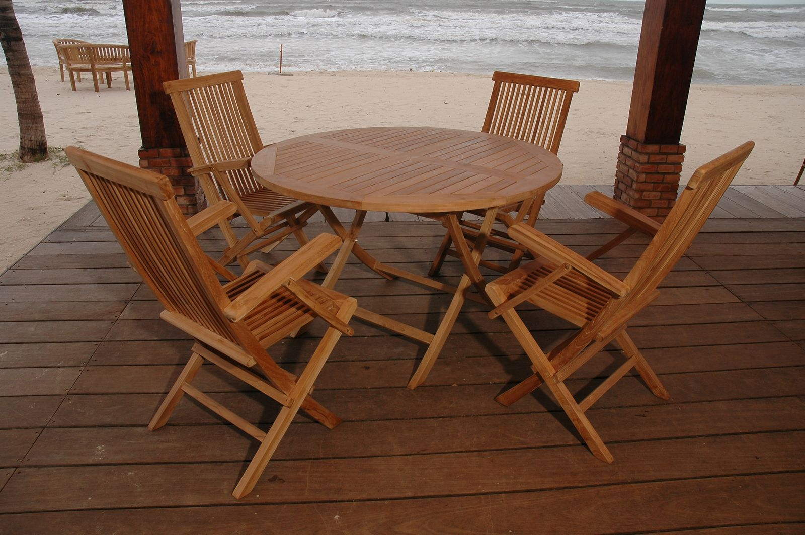Wooden outdoor dining set on a deck with ocean view