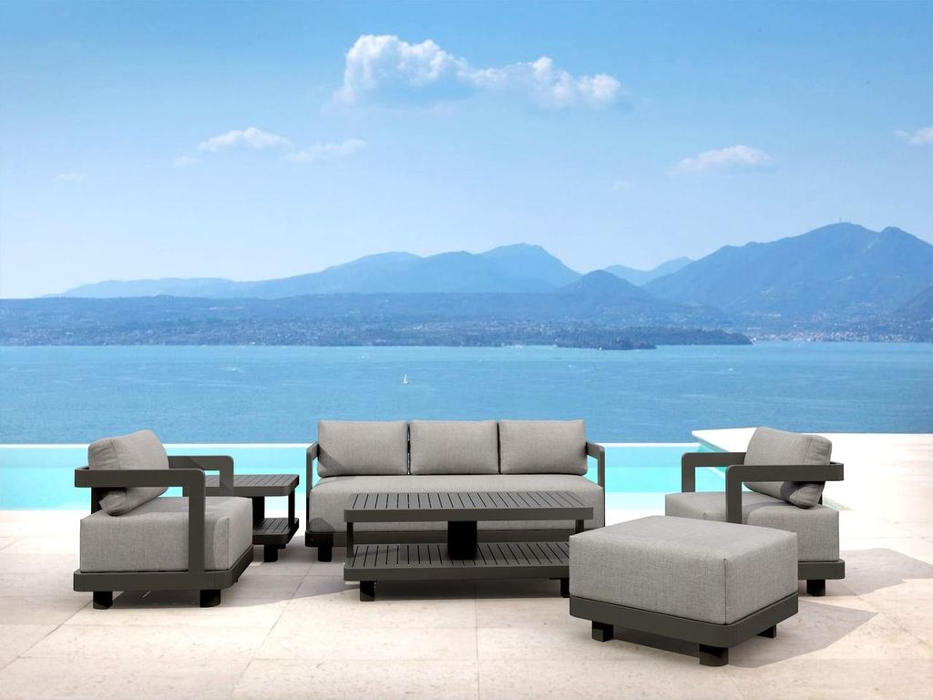 Outdoor furniture set with a scenic view of water and mountains.
