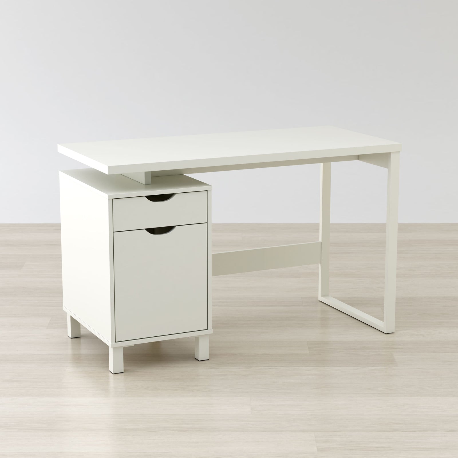 White desk with a drawer on a light wooden floor and white wall background