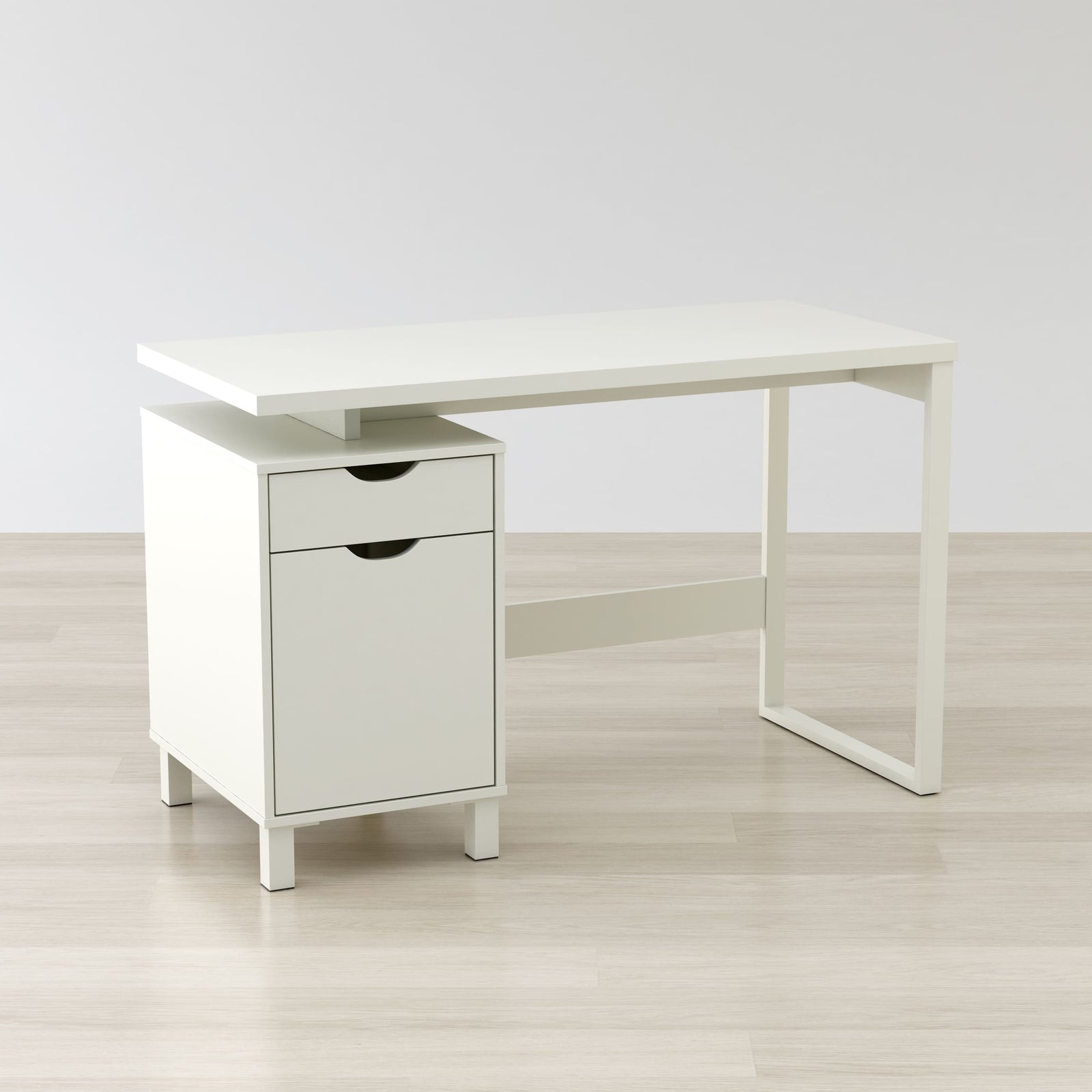 White desk with a drawer on a light wooden floor and white wall background
