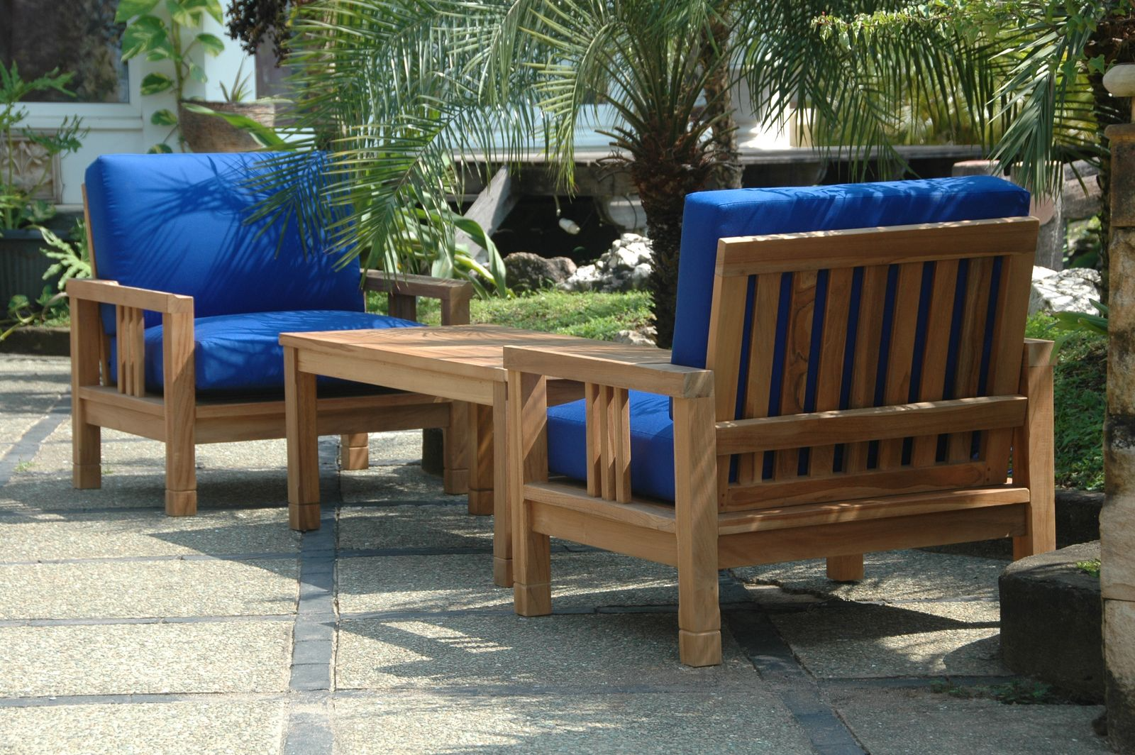 Wooden outdoor furniture set with blue cushions on a patio