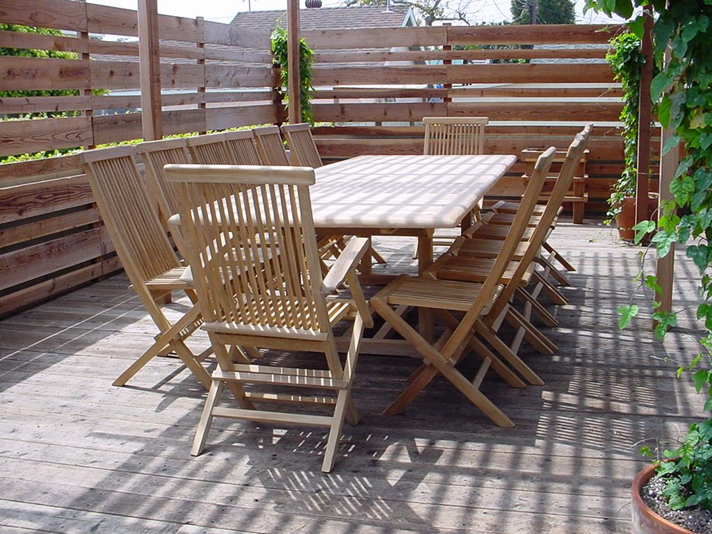 Wooden outdoor dining set with table and chairs on a wooden deck.