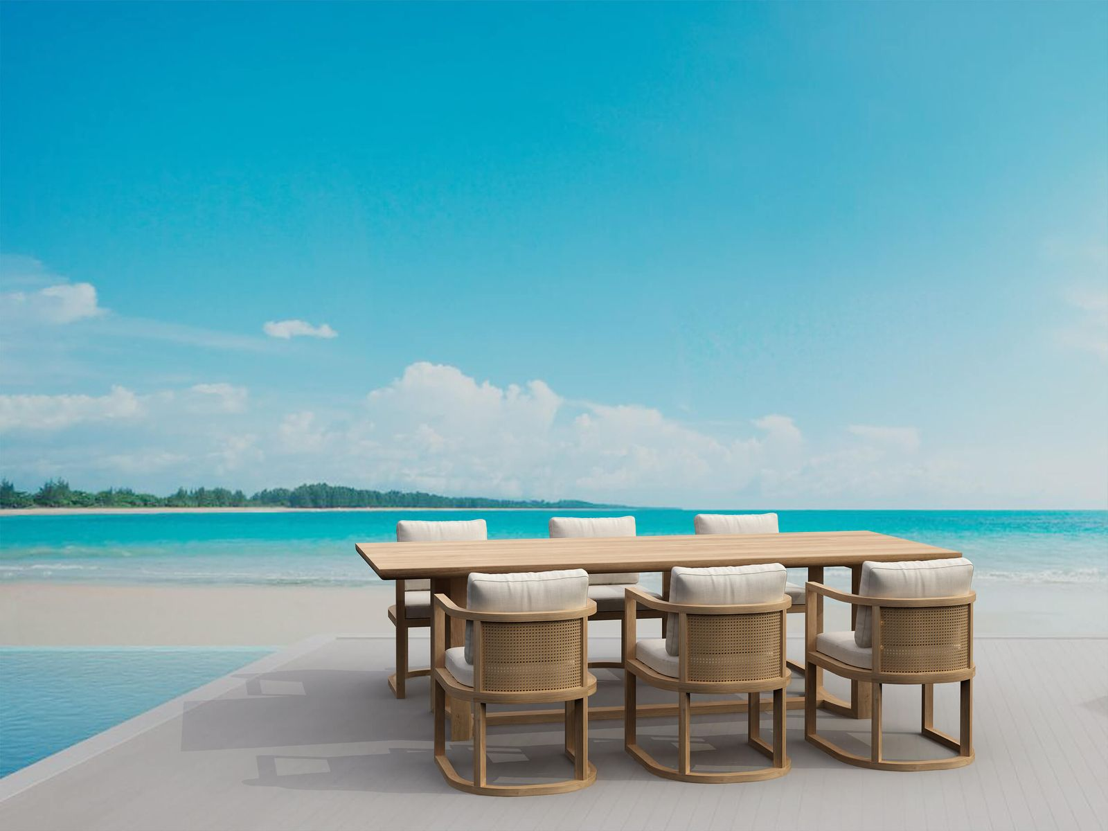 Outdoor dining set with wooden table and chairs on a beach with clear blue sky and ocean.