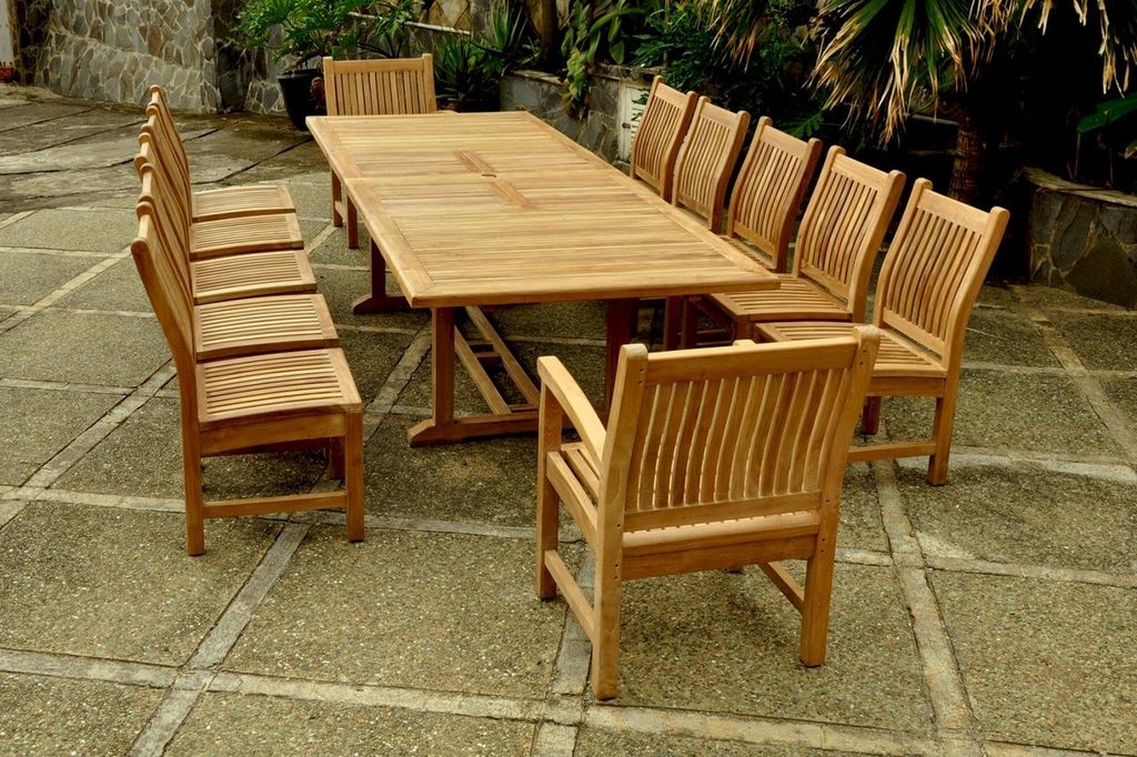 Wooden outdoor dining table with chairs on a stone patio