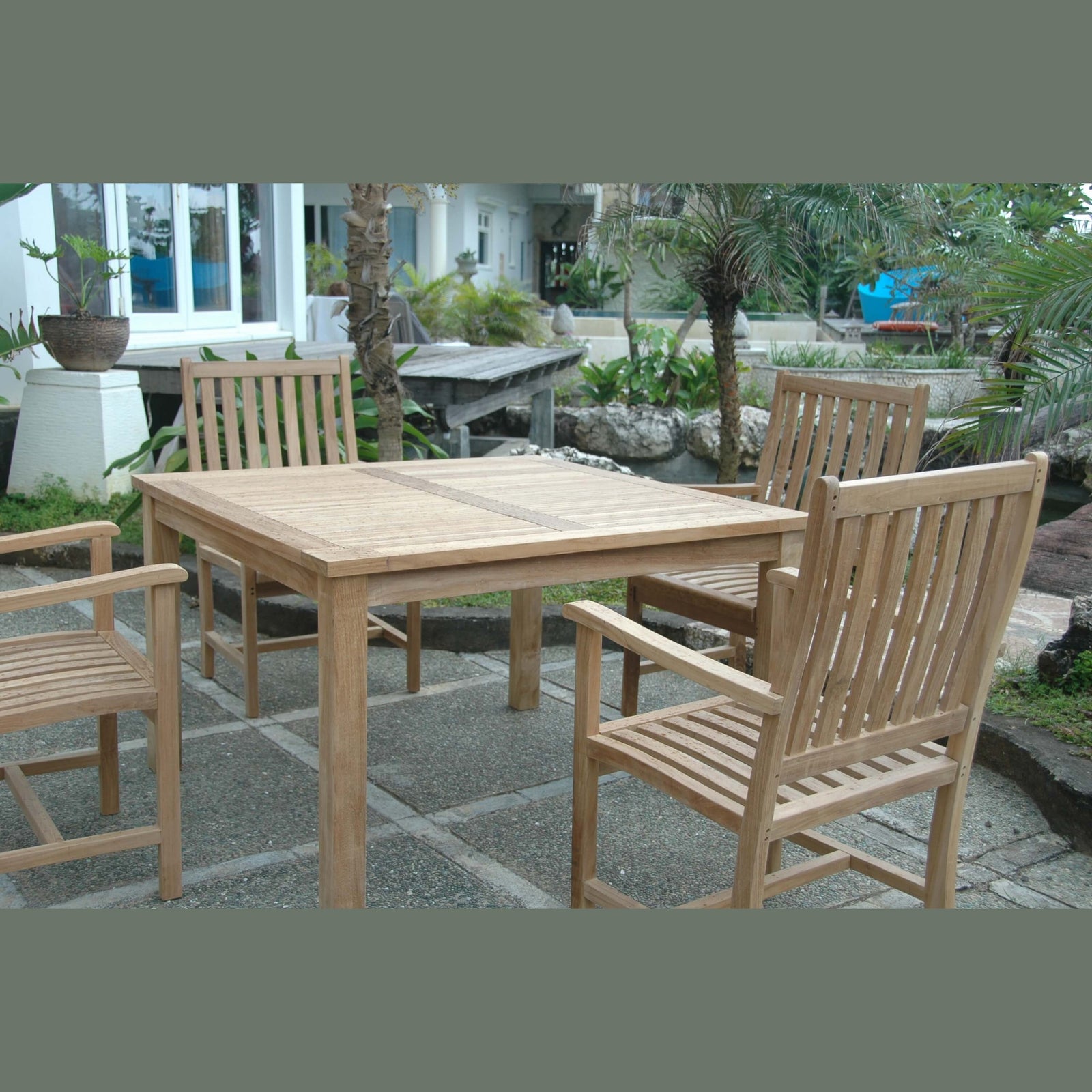 Wooden outdoor dining table with chairs on a stone patio