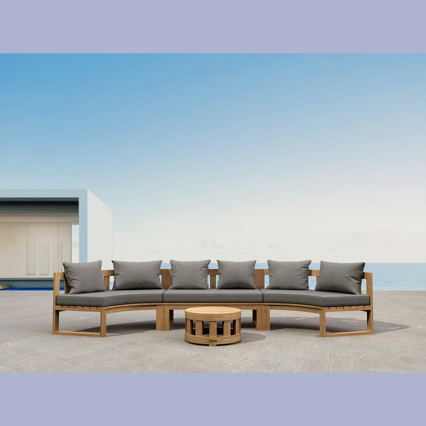 Outdoor patio set with a curved sofa and round table on a clear day.