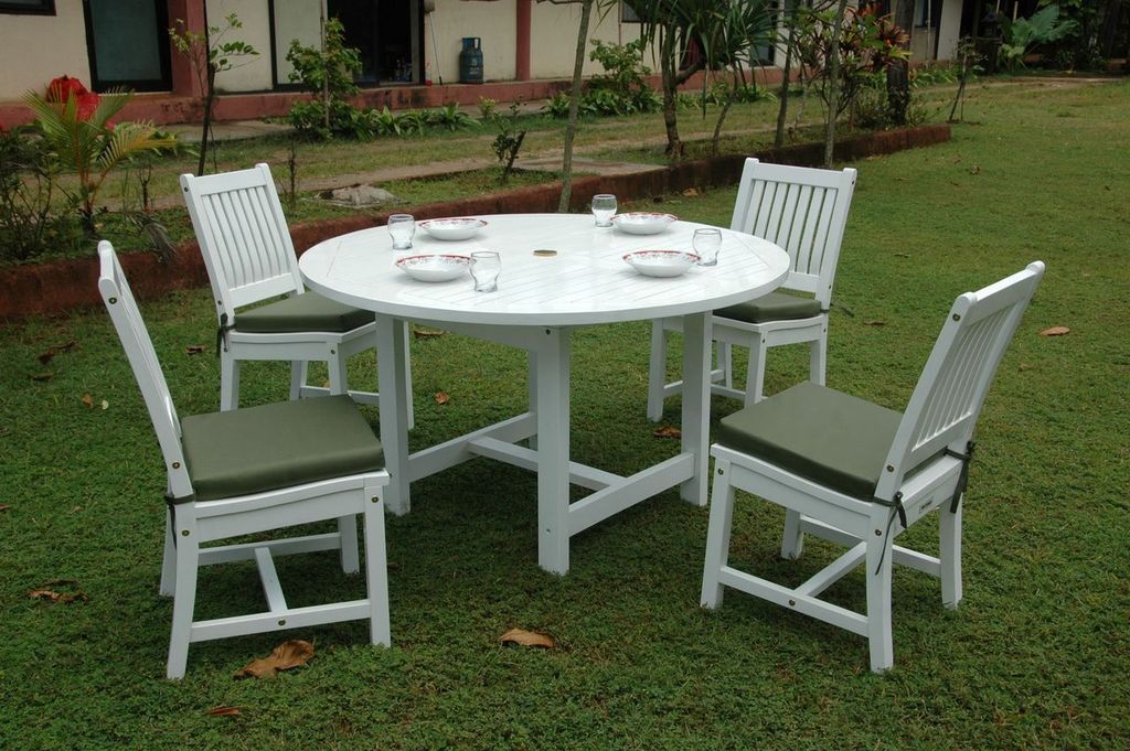 Round white table with four matching chairs on a grassy area