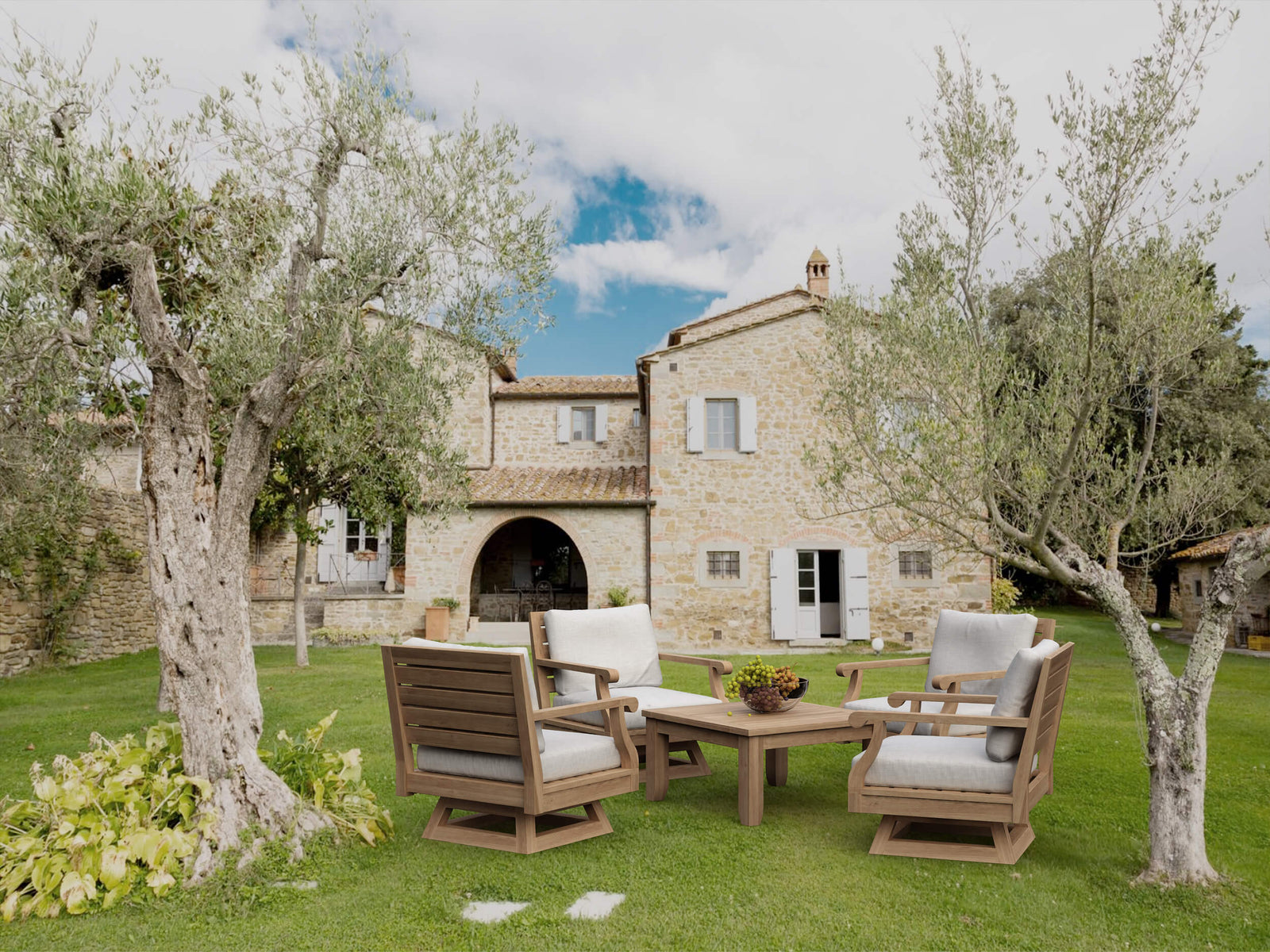 Outdoor furniture set on a grassy area with a stone building in the background