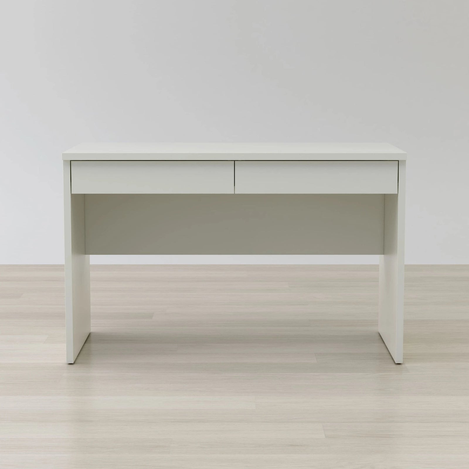 White desk with a light gray panel on a wooden floor and white wall background