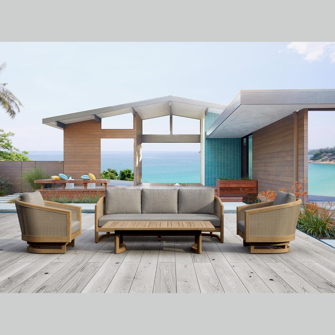 Outdoor patio set with sofa, chairs, and coffee table on a wooden deck with ocean view.