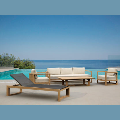 Outdoor furniture set with lounge chair, sofa, and table by a pool with ocean view.