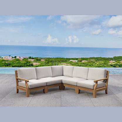 Outdoor sectional sofa with beige cushions on a patio overlooking the ocean.