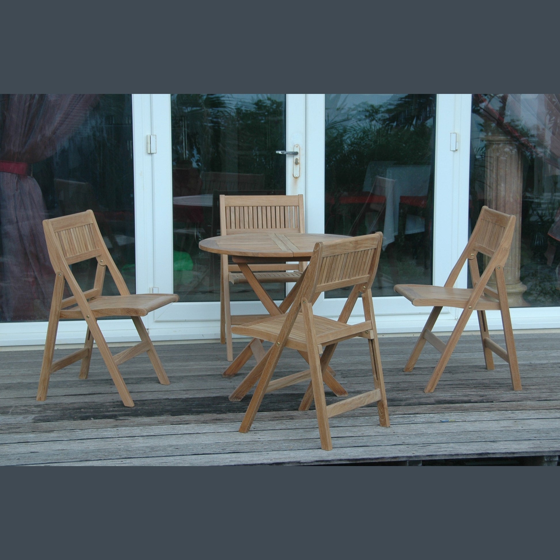Wooden outdoor furniture set with a table and chairs on a wooden deck.