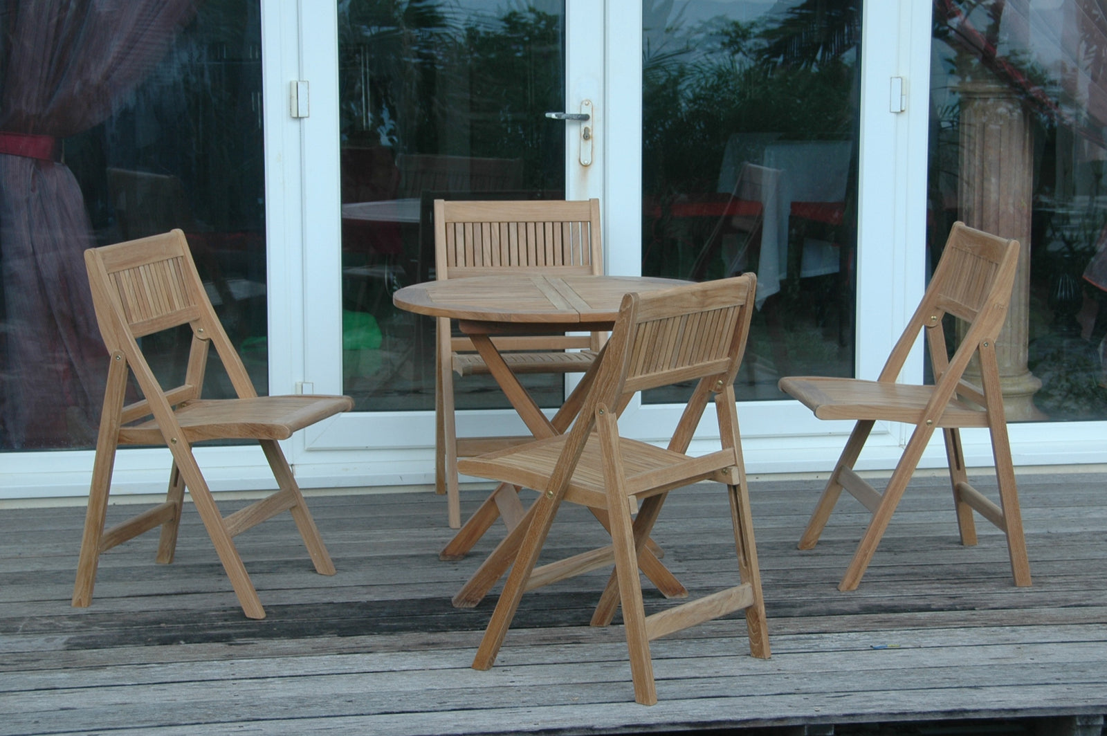 Wooden outdoor furniture set with a table and chairs on a wooden deck.