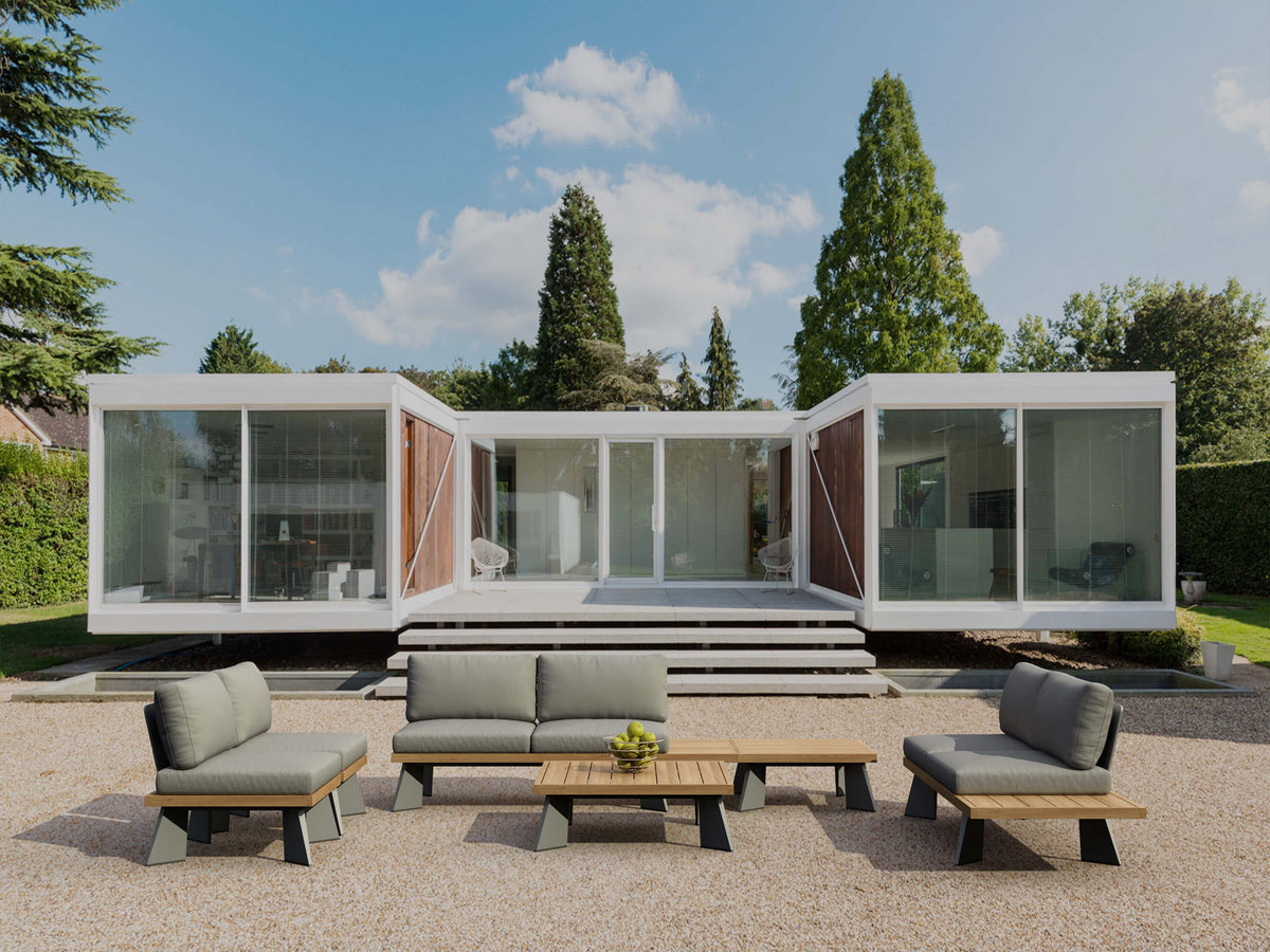 Modern modular building with outdoor furniture set on a clear day